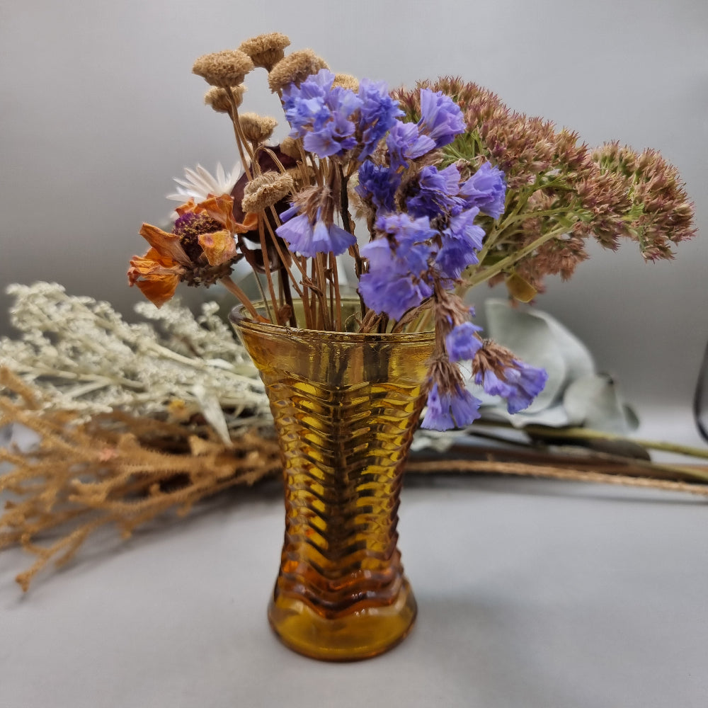 Amber ripple glass vase with hourglass shape and wavy texture.