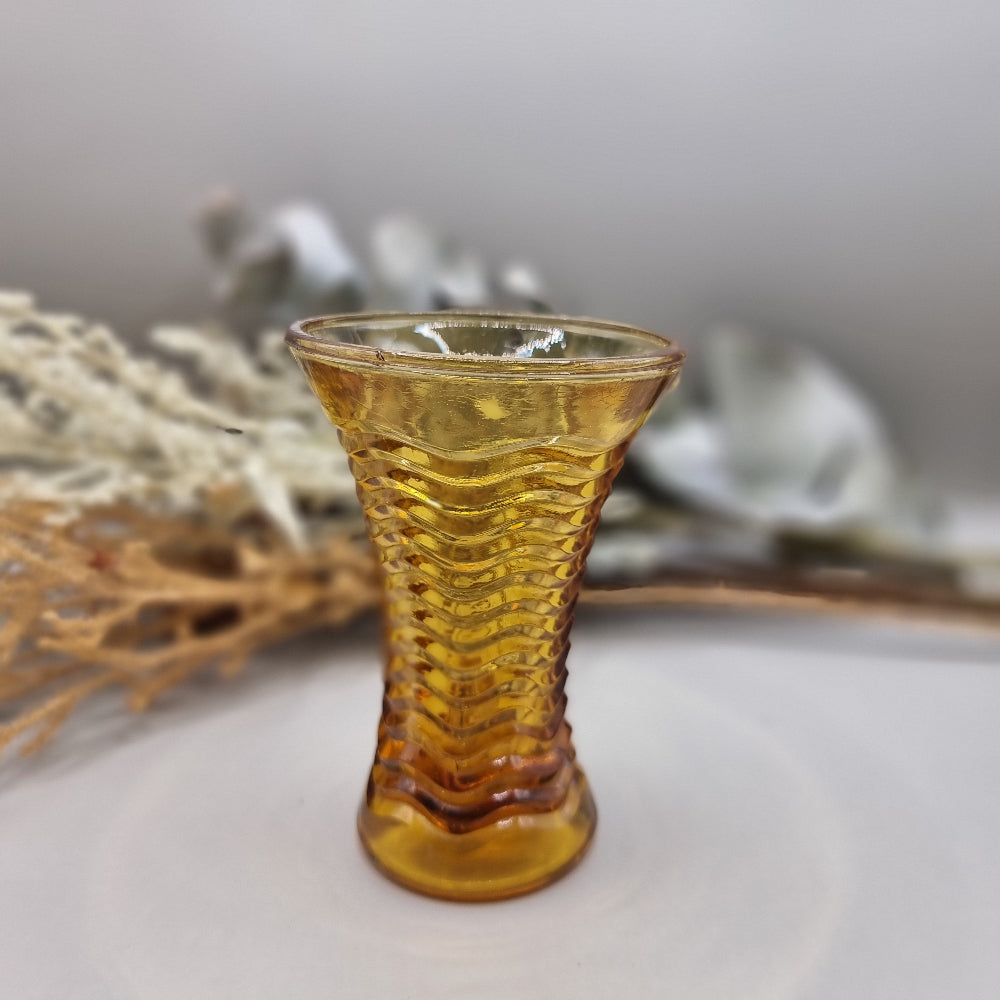 Amber ripple glass vase with hourglass shape and wavy texture.