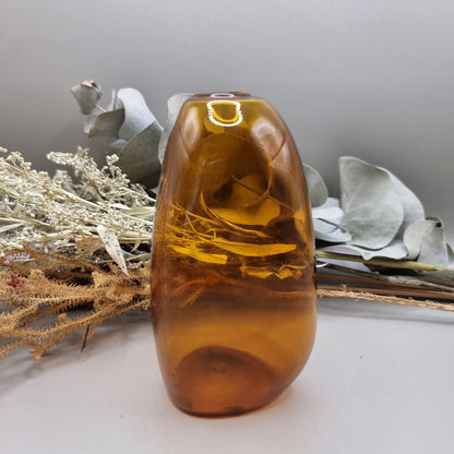 Amber handblown vase with smooth curved shape and small top opening.