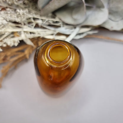 Amber handblown vase with smooth curved shape and small top opening.