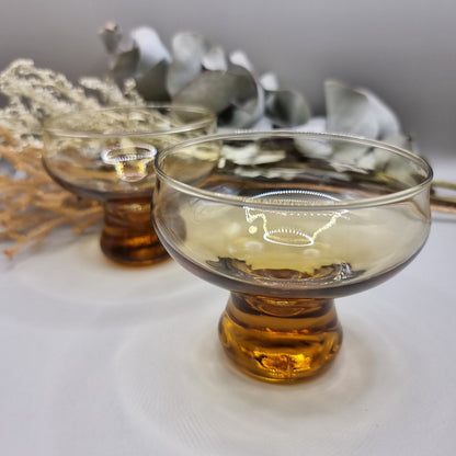 Pair of 1970s Kaaru Honeygold pedestal glasses in amber tint.