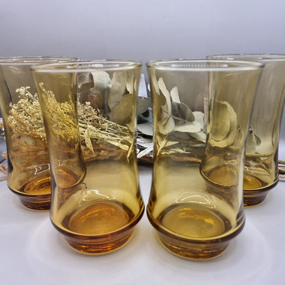 Set of four amber-coloured Kaaru retro glass tumblers with curved shape.