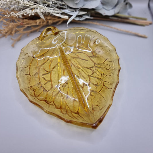 Amber pressed glass dish shaped like a leaf with detailed veins and small handle.