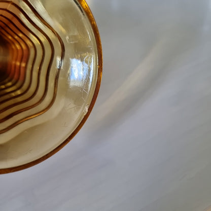 Amber ripple glass vase with hourglass shape and wavy texture.