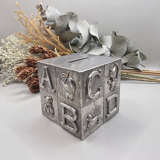 Vintage style silver plated alphabet block money box with raised letters and animal illustrations on each side.
