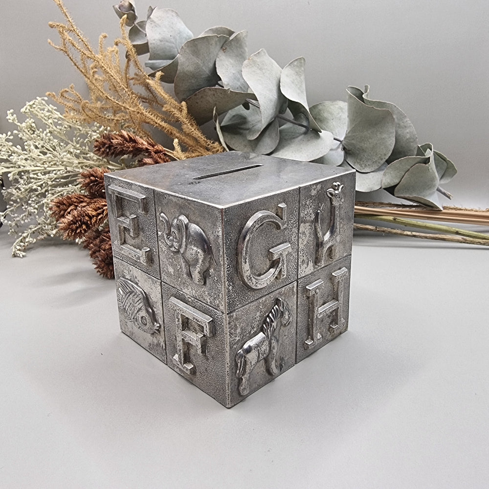 Vintage style silver plated alphabet block money box with raised letters and animal illustrations on each side.