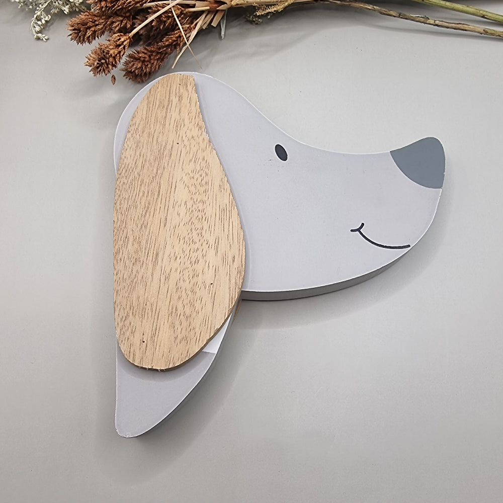 Cute wooden dog face wall hooks with clothes hanging from the nose hook.