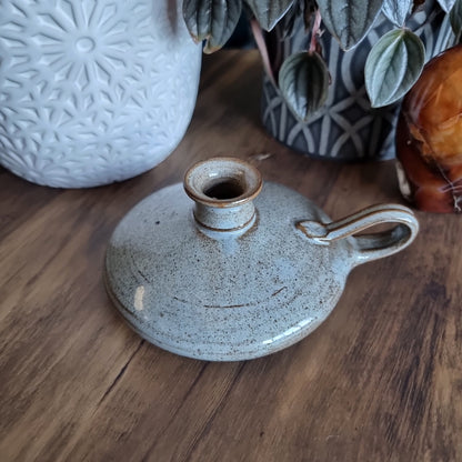 Krums speckled stoneware candle holder with side loop handle and earthy neutral glaze.
