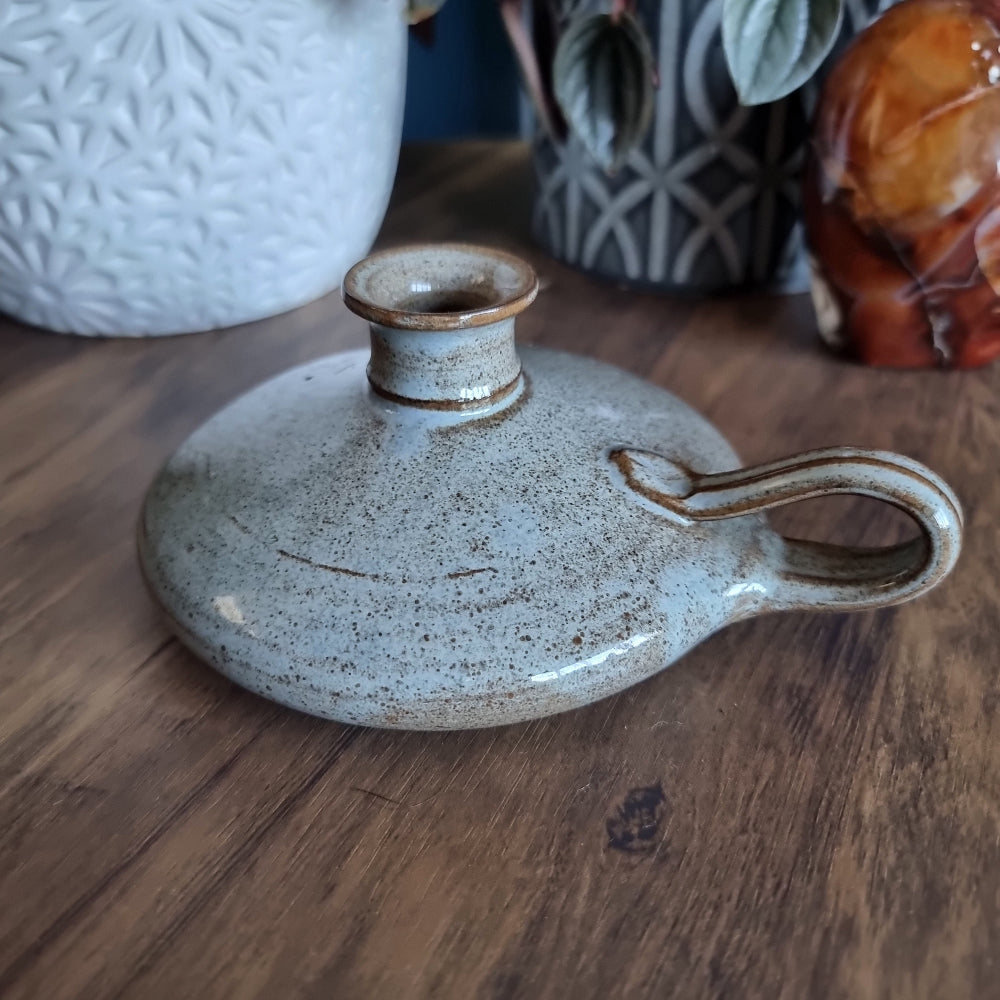 Krums speckled stoneware candle holder with side loop handle and earthy neutral glaze.