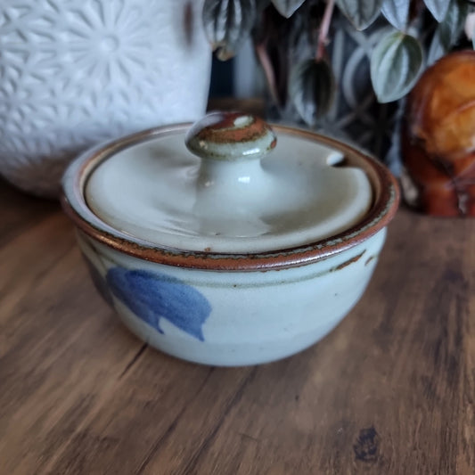 Lidded handmade pottery bowl with brown rim and blue brushstroke design