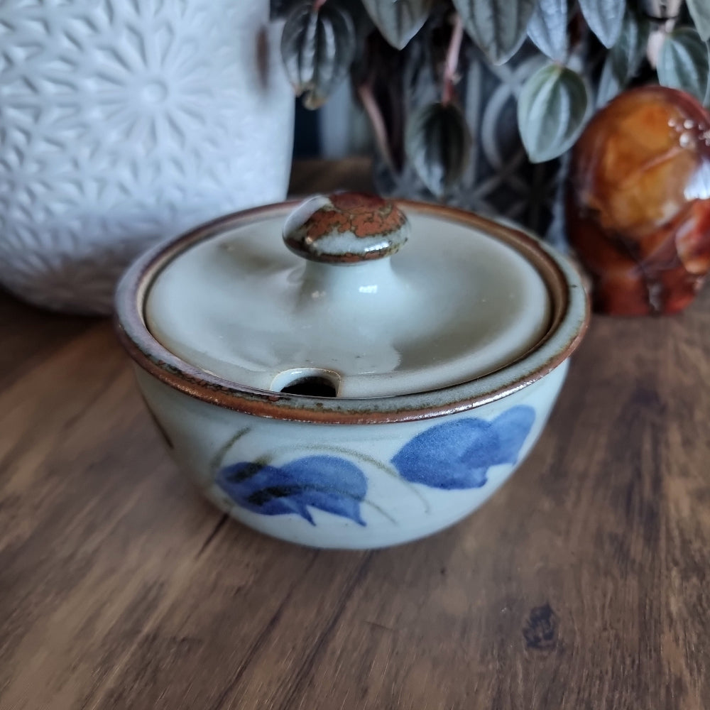 Lidded handmade pottery bowl with brown rim and blue brushstroke design