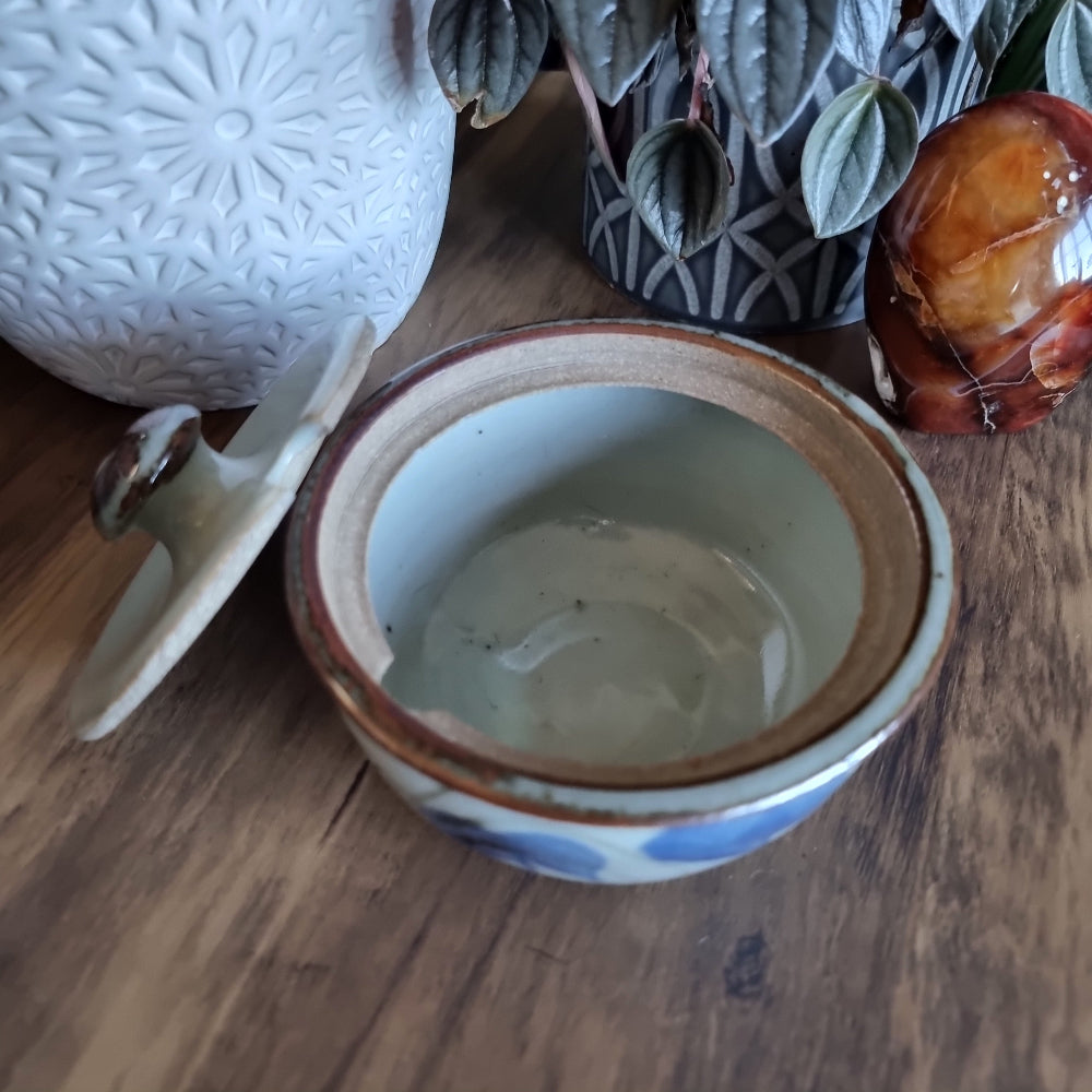 Lidded handmade pottery bowl with brown rim and blue brushstroke design