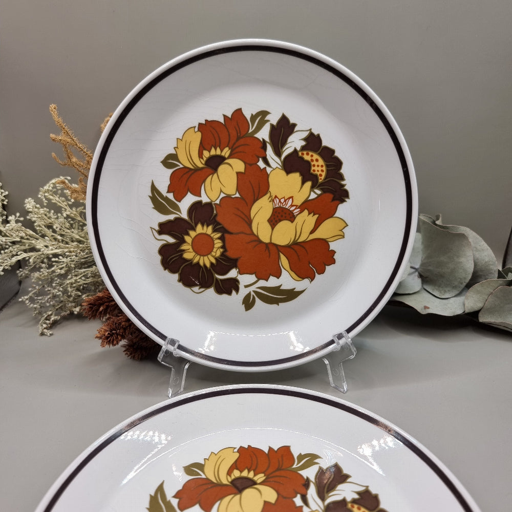 Set of two dinner plates with large 70s floral design in orange, yellow and brown