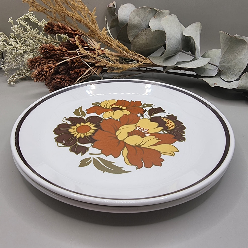 Set of two dinner plates with large 70s floral design in orange, yellow and brown