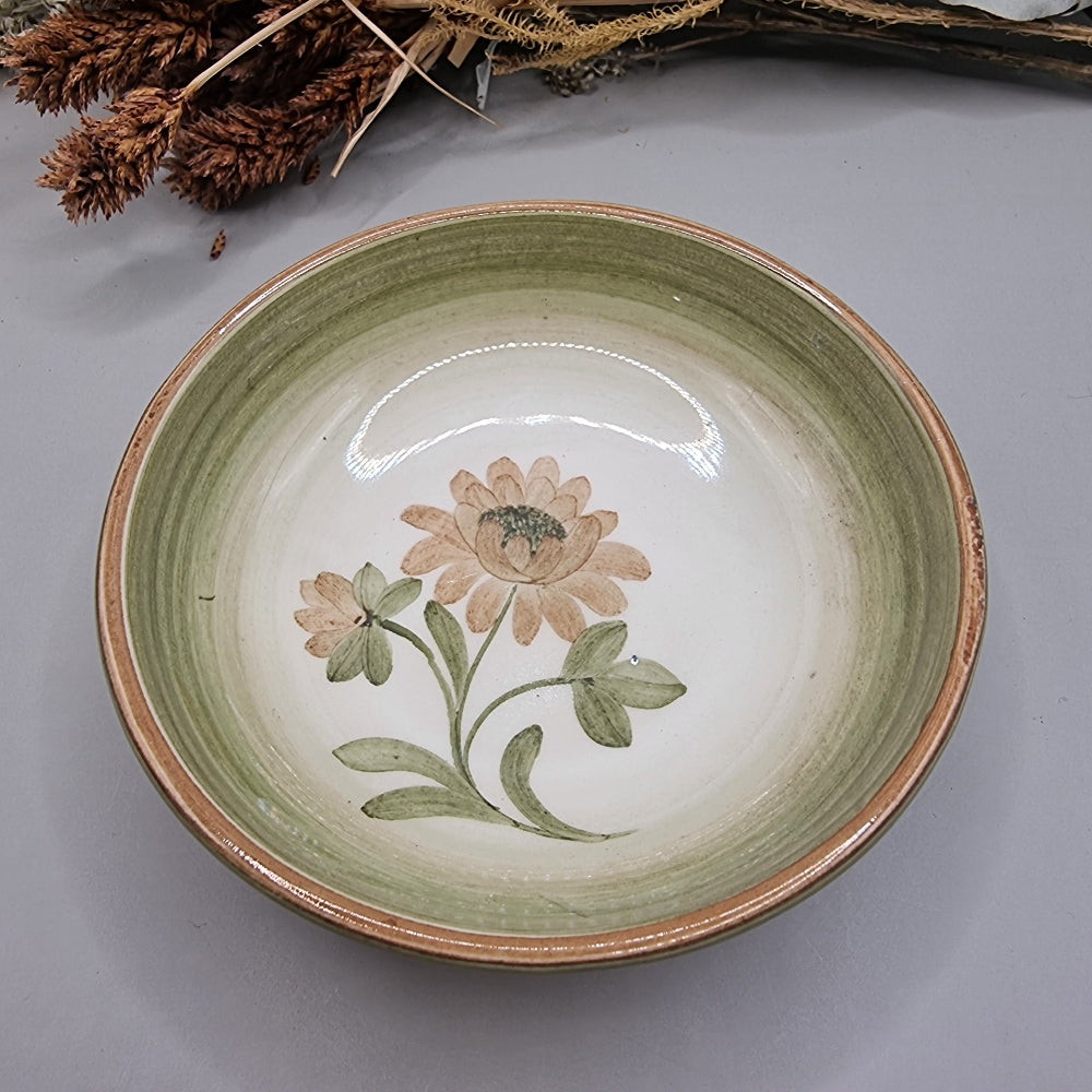 Stoneware bowl with green rim and hand-painted daisy flower in soft earthy tones