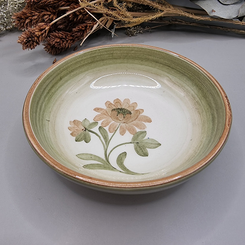 Stoneware bowl with green rim and hand-painted daisy flower in soft earthy tones