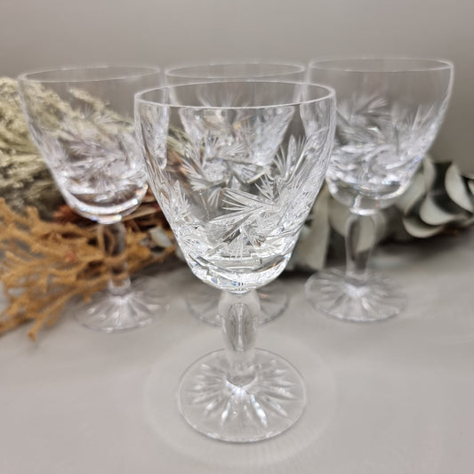 Set of four cut crystal wine goblets with intricate starburst design
