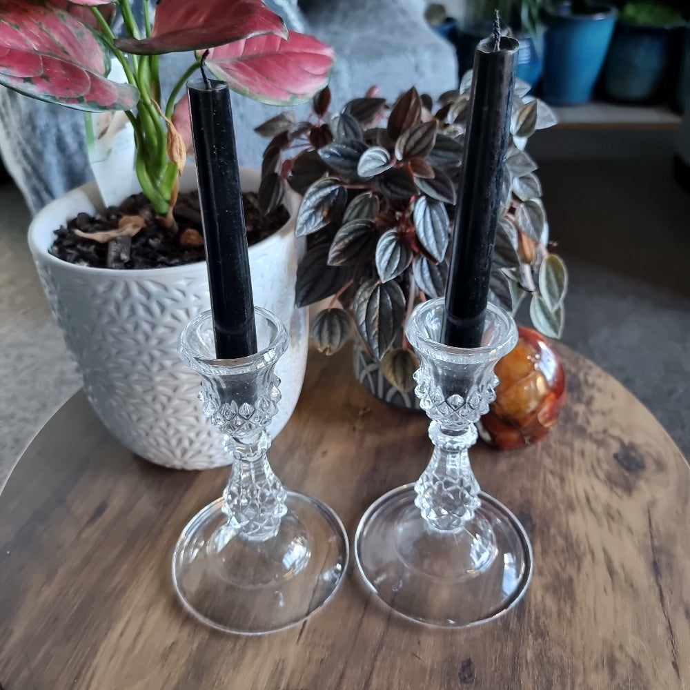 Pair of cut glass candlesticks with black taper candles
