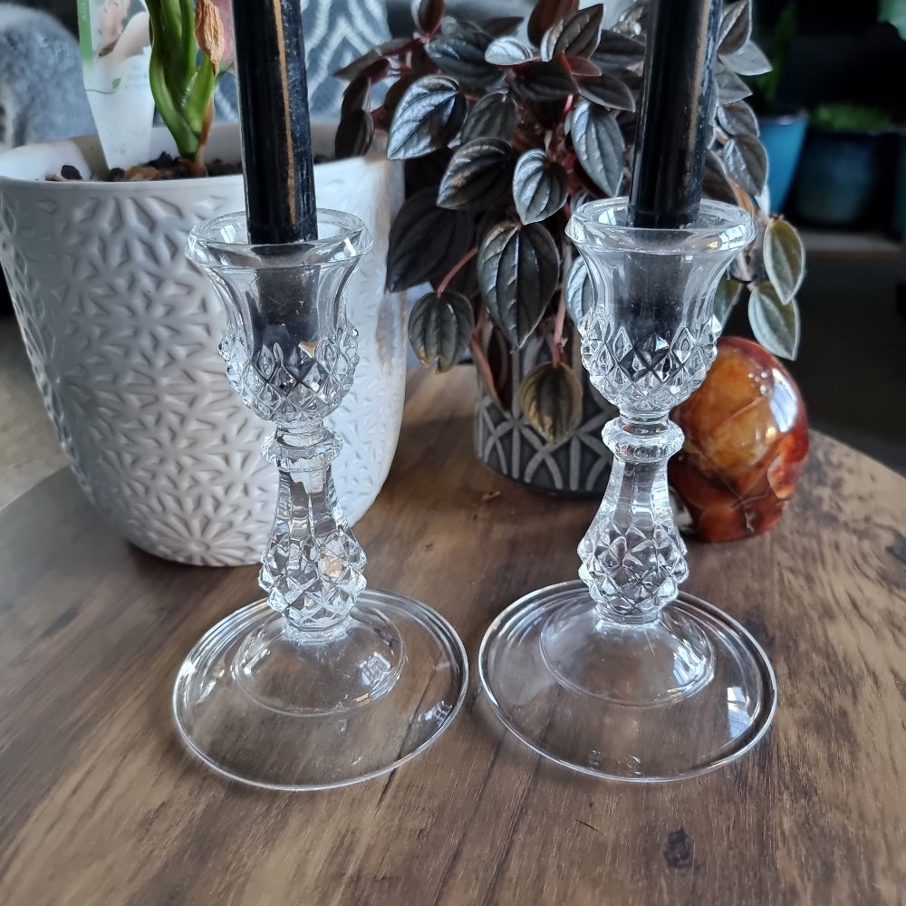 Pair of cut glass candlesticks with black taper candles