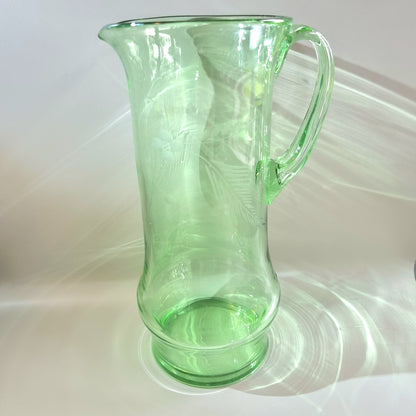 Tall green glass jug with etched floral and fern design and flared rim
