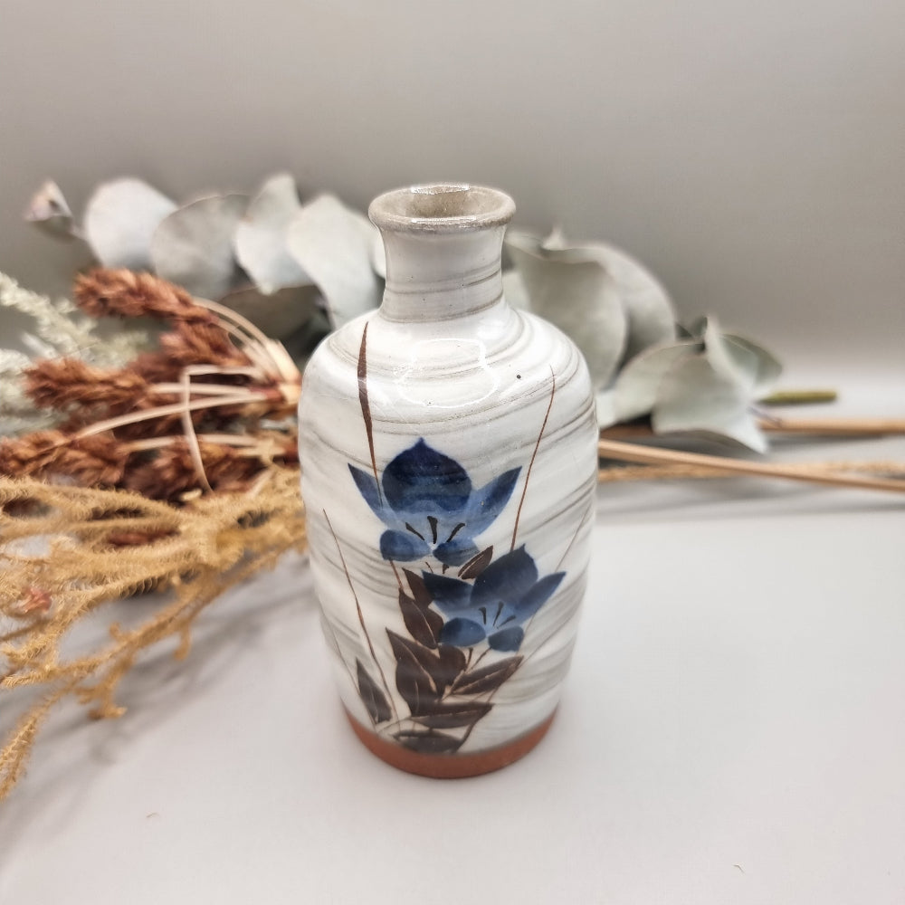 Vintage hand-painted ceramic bud vase with blue floral design and terracotta base.