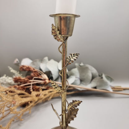 Brass tone metal candle holder with climbing vine and leaf detail.