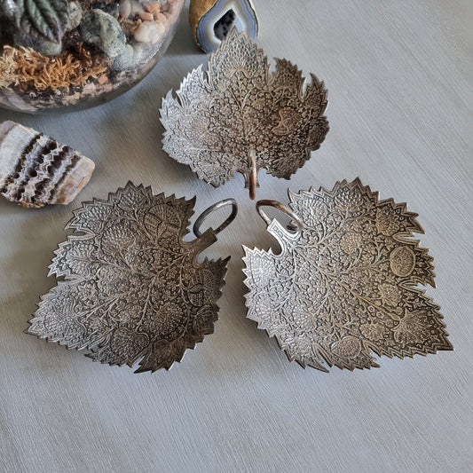 Set of 3 silver-toned metal leaf-shaped dishes with intricate engraved floral patterns