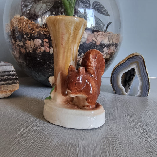Vintage ceramic bud vase featuring a brown squirrel beside a tree stump with earthy glaze and crazing.