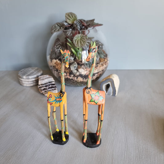 Pair of hand-painted wooden giraffe figurines with colourful folk art designs.
