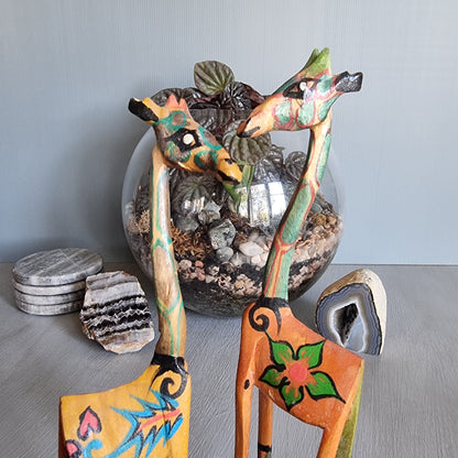 Pair of hand-painted wooden giraffe figurines with colourful folk art designs.