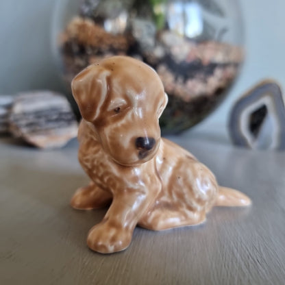 Vintage ceramic puppy figurine in caramel tones, seated with soft expression.