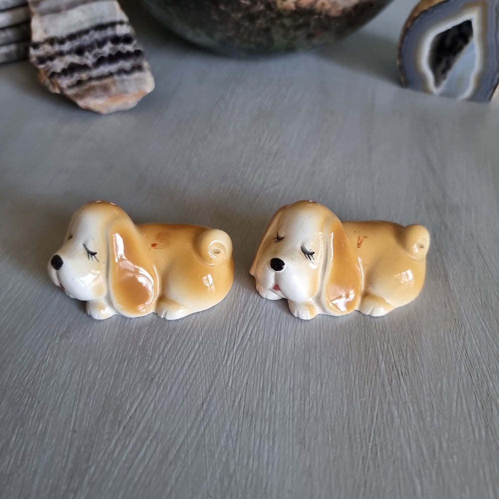 Pair of vintage sleeping dog salt and pepper shakers in caramel and white glaze.