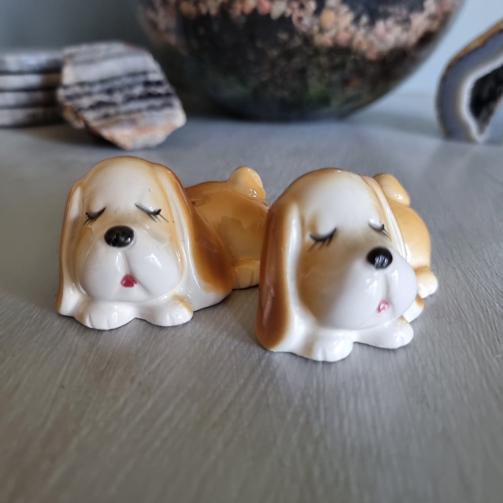 Pair of vintage sleeping dog salt and pepper shakers in caramel and white glaze.
