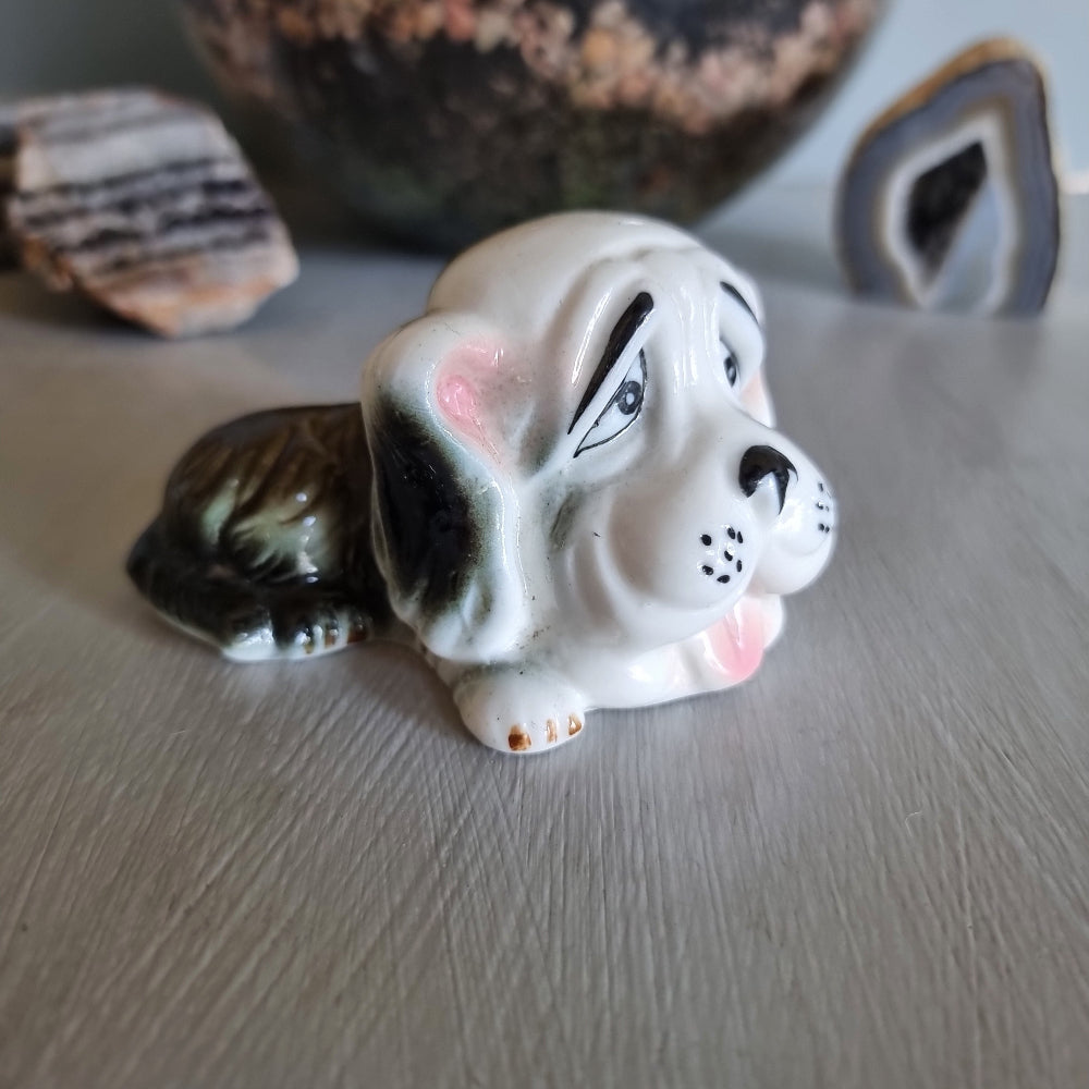Vintage ceramic dog figurine with droopy eyes and pink ears.