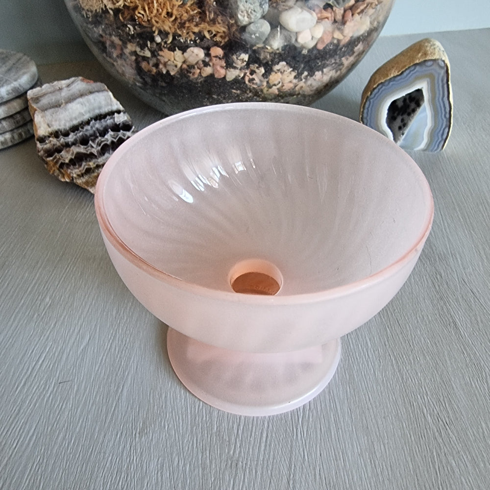 Vintage pink frosted glass bonbon dish with pedestal base and soft swirl pattern.