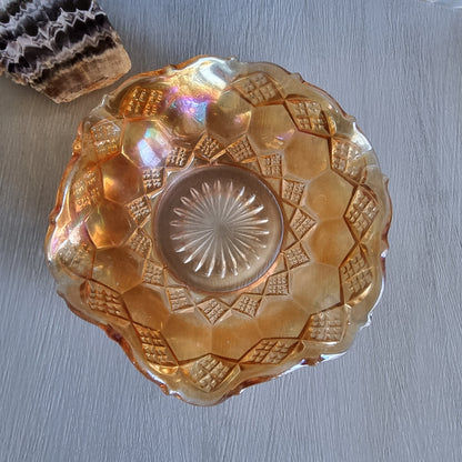Amber carnival glass bowl with diamond pattern and scalloped edge, iridescent finish.