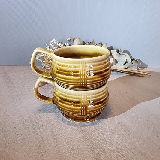 Pair of vintage brown drip-glaze ceramic soup mugs with ribbed design and handles.