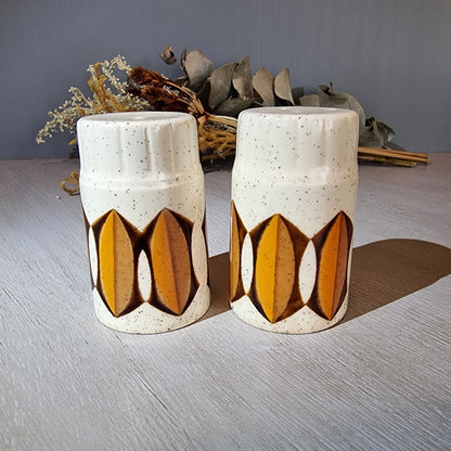 Pair of Palissy salt and pepper shakers with mustard and brown geometric design.