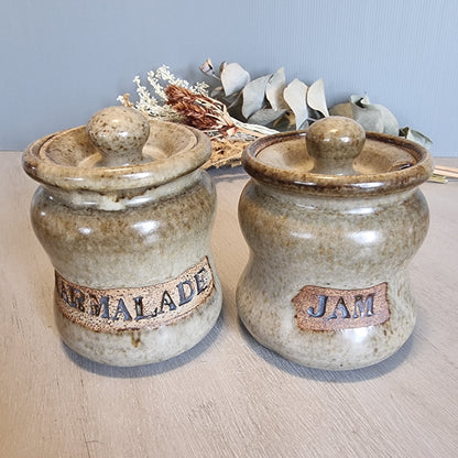 Pair of vintage stoneware jam and marmalade pots with rustic glaze and embossed lettering.