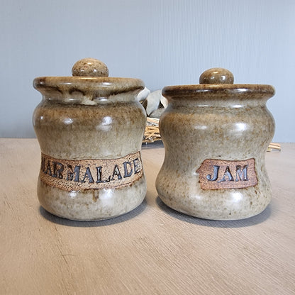 Pair of vintage stoneware jam and marmalade pots with rustic glaze and embossed lettering.