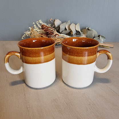 Pair of vintage brown and caramel stoneware mugs with glossy glaze.