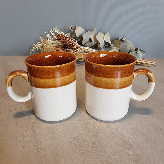 Pair of vintage brown and caramel stoneware mugs with glossy glaze.