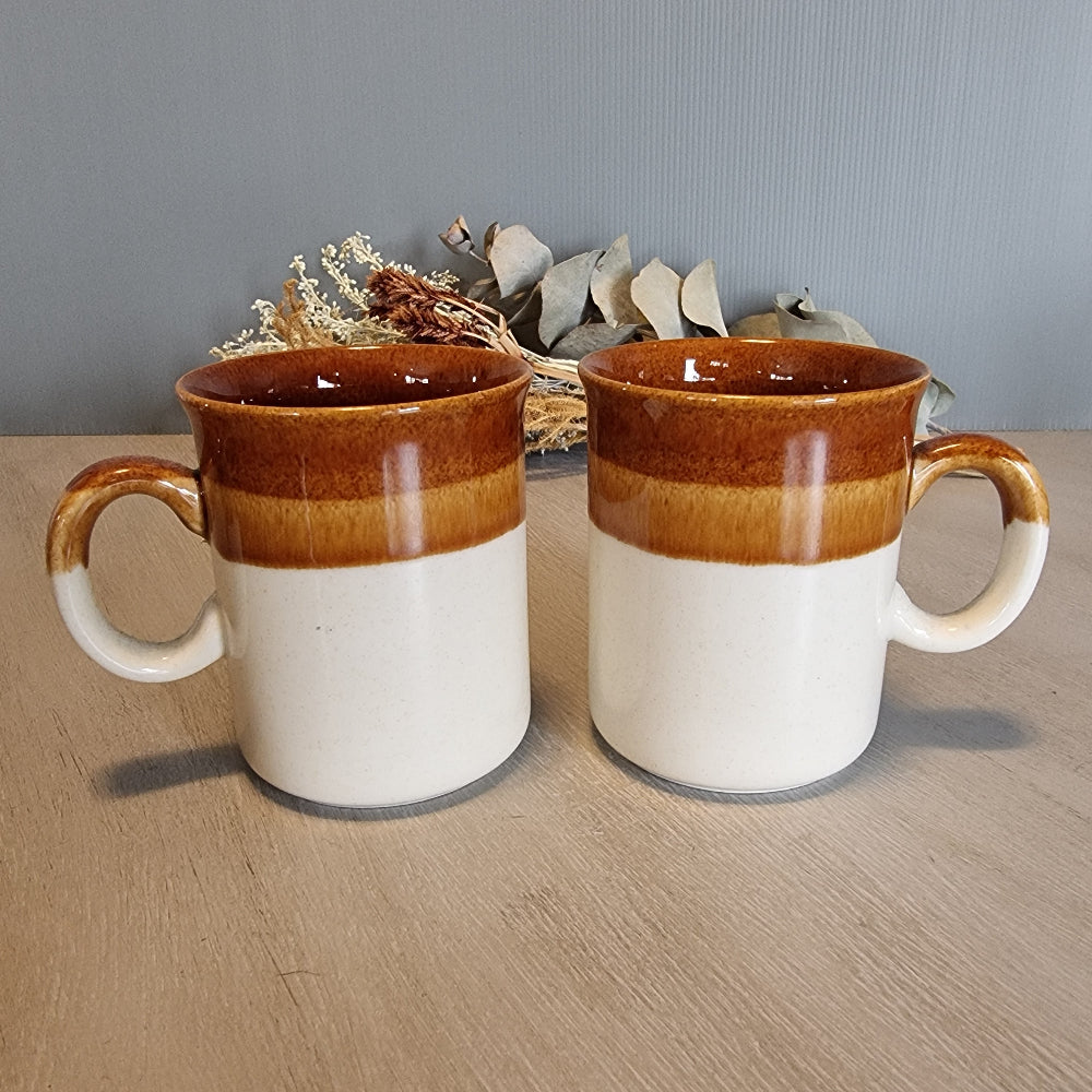 Pair of vintage brown and caramel stoneware mugs with glossy glaze.