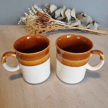 Pair of vintage brown and caramel stoneware mugs with glossy glaze.
