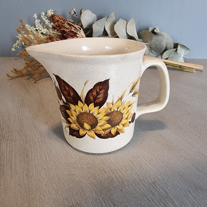 Vintage ceramic jug with bold sunflower design on speckled base.