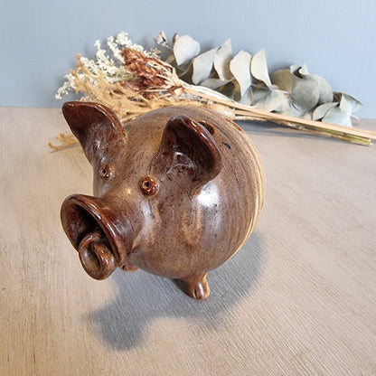 Vintage brown ceramic pig figurine with glossy glaze and open holes across the top
