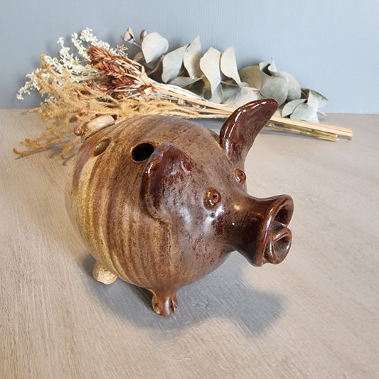 Vintage brown ceramic pig figurine with glossy glaze and open holes across the top