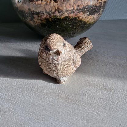 Rustic ceramic bird ornament with natural wood-tone finish.