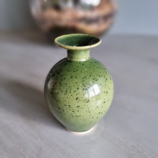 Small green speckled pottery vase with glossy glaze.