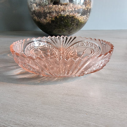 Vintage pink Depression glass bowl with scalloped edge and pressed pattern.